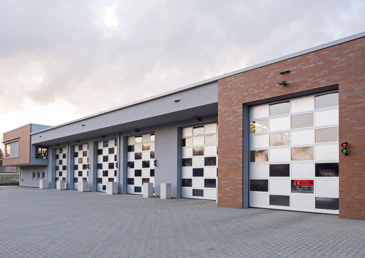 Grandes puertas de garaje industriales con paneles de cristal en Murcia